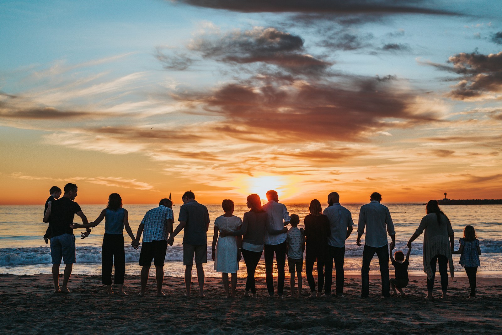 Multi-generation family gathered on the beach at dusk